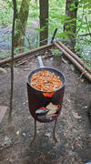 Frisch gebratene Pilzpfanne auf dem offenen Feuer im Wald.